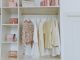 A white closet with clothes on hangers and purses